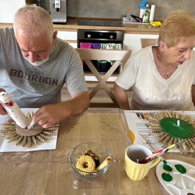 Seniorzy robią papierowe słoneczniki do ozdoby dożynkowej