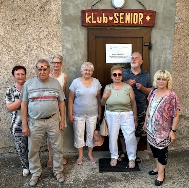 klubowicze przy napisie klubu senior wyrzeźbionym przez lokalnego artystę