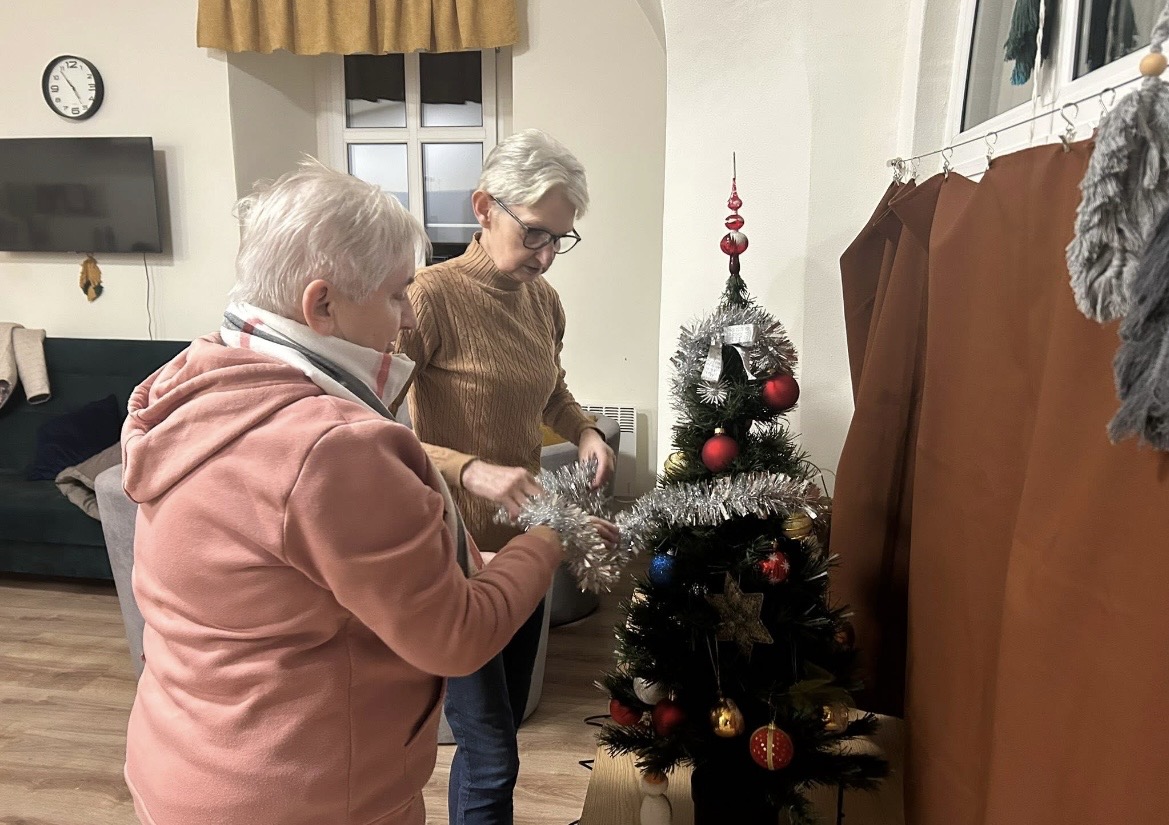 na zdjęciu klubowicze ubierają choinkę i przystrajają świątecznie klub